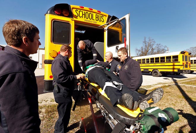 Members of Northport Fire Rescue practice patient rescue and evacuation, using Sgt. Johnny Osborne as their patient, at the Tuscaloosa County School System Transportation Department on 68th Avenue in Northport Tuesday, Jan. 27, 2015. NFR contacted the Tuscaloosa County Board of Education to review school bus evacuation procedures and to practice treating patients in the case of an emergency. "It's not something that you do every day, but it plays an important role when a school bus is involved in an accident," said NFR Chief Bart Marshall. There have been at least three school bus accidents in the state of Alabama in the last week. Michelle Lepianka Carter | The Tuscaloosa News