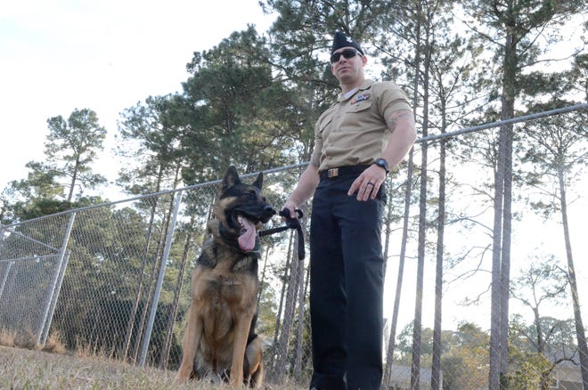 Master-at-Arms 2nd Class Cameron Smith and his dog prepare to enter the 25 pound and larger area of the Barks and Recreation Dog Park.