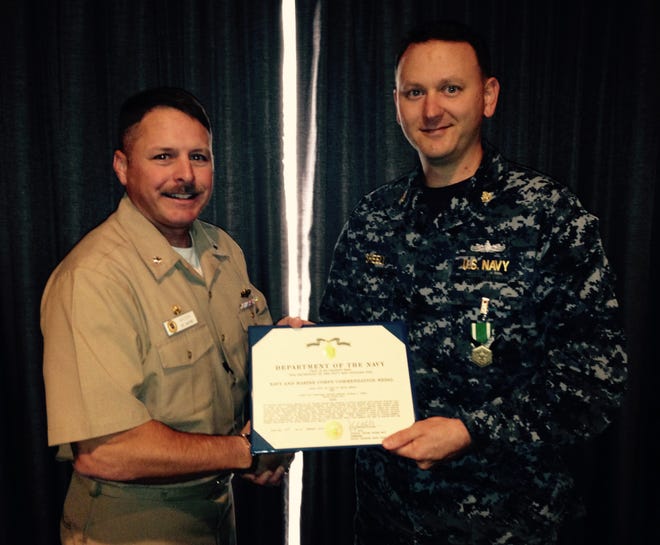 Commanding Officer of Afloat Training Group Mayport, Cmdr. Adam Aycock, presents FCC (SW) Michael Sheely with the Navy Marine Corps Commendation Medal.