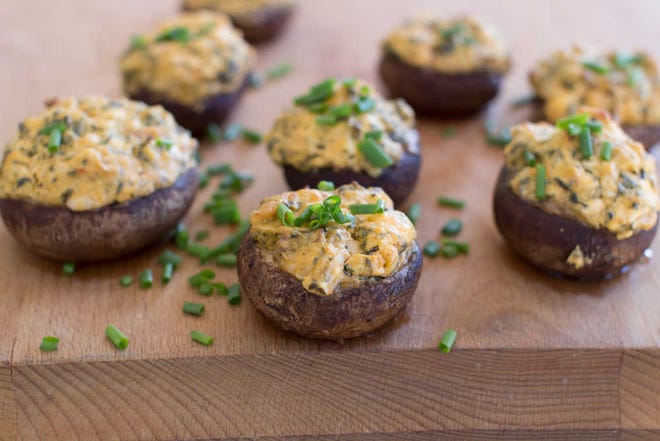 This Dec. 15, 2014, photo shows Buffalo chicken and kale-stuffed mushrooms in Concord, N.H. This dish takes the flavors of a Buffalo wing and stuffs them into a mushroom cap and then is baked, making for a great, healthy tailgating snack.