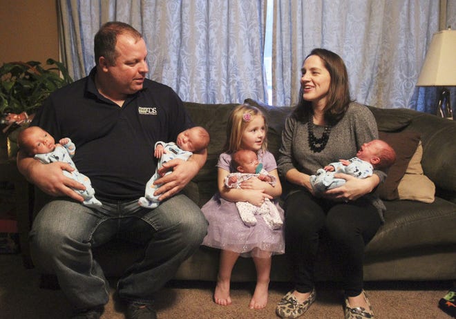 Shane Burchett holds his sons Brock and Corbin while Brielle, 4, holds Hadley and Tabitha holds Grayson at their home in Shreve, Ohio, on Wednesday, Jan. 21.