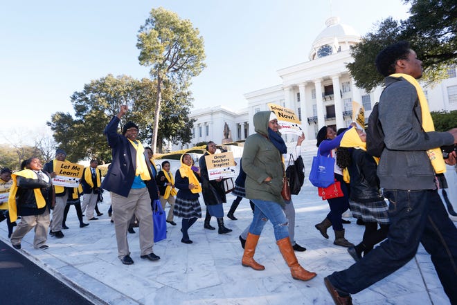 Students and teachers participating in a National School Choice Week rally pass in front of the Alabama State Capitol, Wednesday Jan. 28, 2015, in Montgomery, Ala. Parents and students rallied on the lawn of the Alabama Capitol Wednesday, urging state politicians to provide more publicly funded education options.(AP Photo/Hal Yeager)
