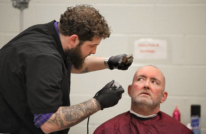 Michael Darling gets a haircut and beard grooming from Mansfield resident Brennan Robinson, aka Divino the Barber, during the Community Shelter Board's annual homeless census.