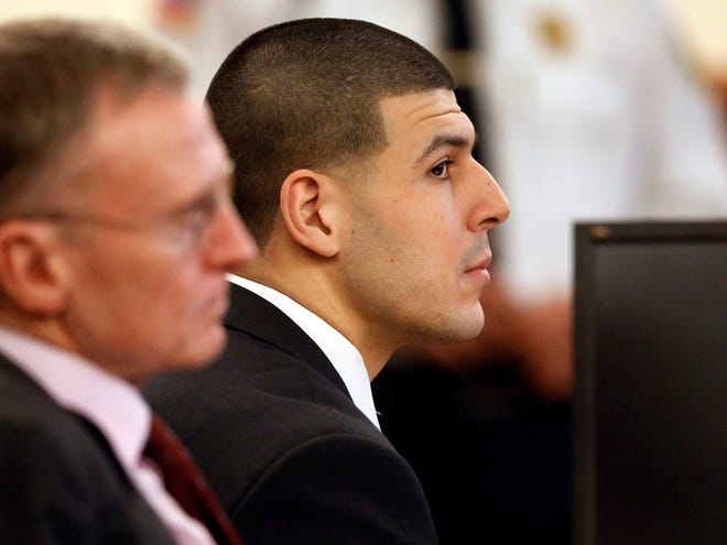 Former New England Patriots and Florida Gators football player Aaron Hernandez, right, listens during his murder trial as defense attorney Charles Rankin, left, looks on Thursday in Fall River, Mass.