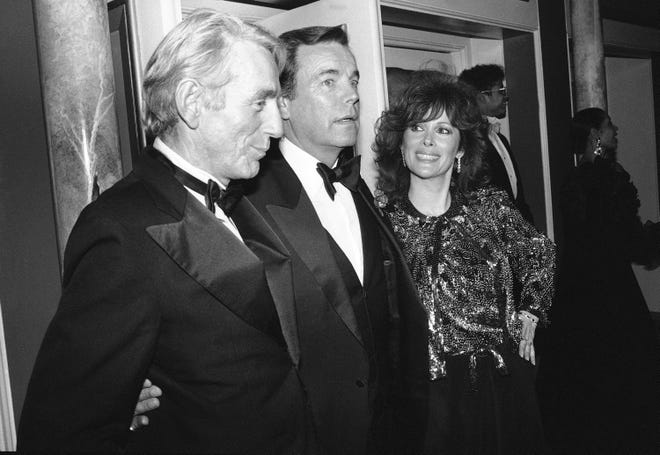 FILE - In this Feb. 18, 1985 file photo, Jill St. John, right, with Robert Wagner, center, and Rod McKuen, left, attend a party for "Night of 100 Stars II," in New York. McKuen, the husky-voiced "King of Kitsch" whose music and verse recordings won him an Oscar nomination and made him one of the best-selling poets in history, has died on Thursday, Jan. 29, 2015. He was 81. (AP Photo/Rene Perez, File)