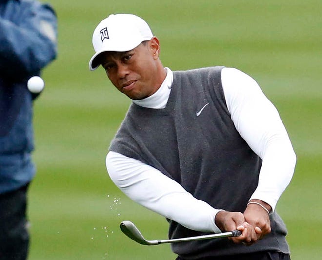 Tiger Woods hits an iron shot on the ninth hole Friday during the second round of the Phoenix Open. Woods shot an 82.