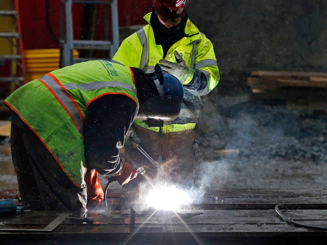 Workers weld at a commercial construction site on Jan. 12 in Boston. The economy, as measured by the gross domestic product, grew at a 2.6 percent annual rate in the October-December period, the government said Friday.