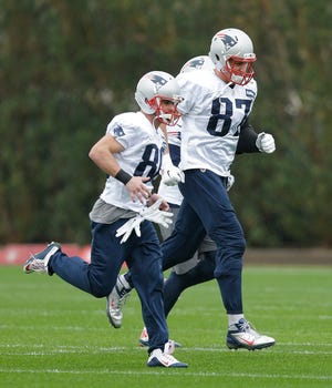 Patriots tight end Rob Gronkowski (87) warms up with wide receiver Danny Amendola (80) during practice Friday.