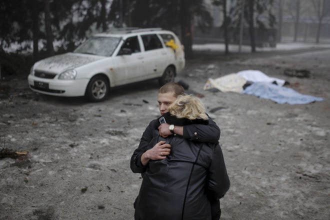 A rebel comforts the wife of a civilian in shelling in Donetsk, eastern Ukraine. Artillery fire in the rebel stronghold killed at least 12 civilians on Friday as fighting intensified between pro-Russia separatists and government troops.