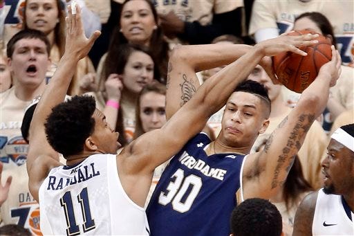 Notre Dame's Zach Auguste (30) looks to pass as Pittsburgh's Derrick Randall (11) defends in the first half of an NCAA college basketball game, Saturday, Jan. 31, 2015, in Pittsburgh. (AP Photo/Keith Srakocic)