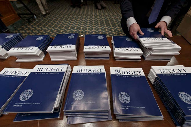 FILE - In this March 4, 2014 file photo, copies of President Barack Obama's proposed fiscal 2015 budget are set out for distribution on Capitol Hill in Washington. The Congressional Budget Office says the federal budget deficit will shrink this year to its lowest level since President Barack Obama took office. CBO says the deficit will be $468 billion for the budget year that ends in September. That's slightly less than last year's $483 billion deficit. As a share of the economy, CBO says this year's deficit will be slightly below the historical average of the past 50 years. (AP Photo/J. Scott Applewhite, File)