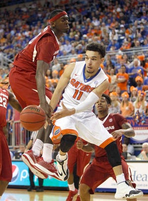 Florida guard Chris Chiozza (11) passes around Arkansas forward Bobby Portis (10) during the second half of an NCAA college basketball game at the Stephen C. O'Connell Center, Saturday, Jan. 31, 2015, in Gainesville, Fla. (AP Photo/The Gainesville Sun, Matt Stamey) THE INDEPENDENT FLORIDA ALLIGATOR OUT