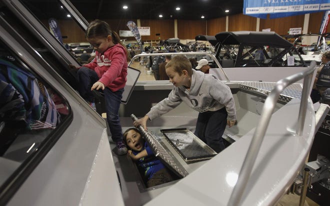 Alvin Sixkiller emerges from a boat’s holding tank as his friend Addison Washburn holds open the door. Alvin’s sister, Olivia, climbs into the boat at the Boat & Sportsmen’s show Saturday. The children were there with Alvin and Olivia’s father, Kelly. (Andy Nelson/The Register-Guard)