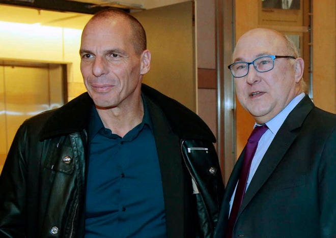 Greek Finance Minister Yanis Varoufakis, left, is greeted by his French counterpart Michel Sapin, at the Economy Ministry in Paris, Sunday Feb. 1, 2015. Finance Minister Yanis Varoufakis, who had a tense meeting with Eurogroup leader Jeroen Dijsselbloem in Athens on Friday, has brought forward a trip to Paris, London and Rome to meet his counterparts. (AP Photo/Jacques Demarthon, Pool)