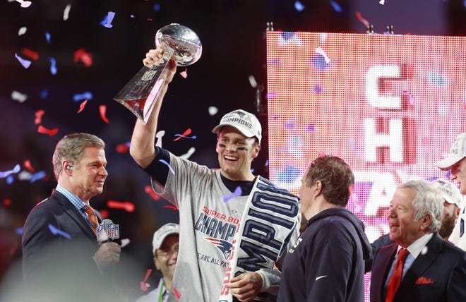 Tom Brady hoists the Lombardi Trophy at the end of the game, on stage with team owner Robert Kraft, right, coach Bill Belichick, second from right, and NBC Sports' Dan Patrick, left.