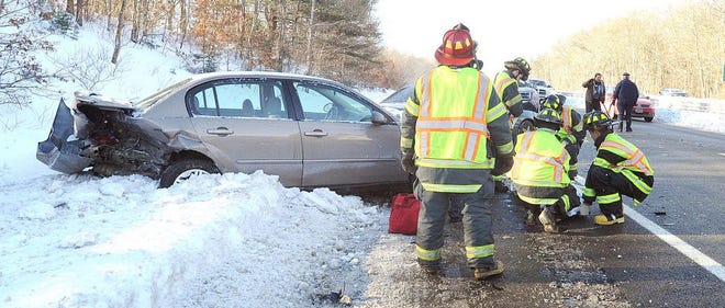 Freetown firefighters bundle a patient against the cold at the scene of a crash on Route 24 northbound Tuesday morning. Another victim had been taken to a rescue unit on the scene. The patient seen here was taken to a fire truck to be kept warm while awaiting an ambulance.