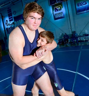 Peoria Notre Dame high school wrestlers Dom Tudor, heavyweight, and J.P. Stedwill who tips the scale around 104, represent the big and small size on the Notre Dame varsity team, have a combined 62-1 record this season.