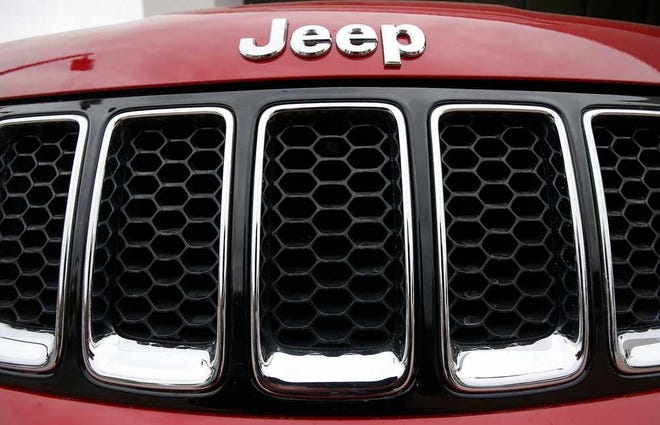 FILE - This Tuesday, Dec. 2, 2014, file photo, shows the Jeep logo on a Cherokee vehicle at a local car dealership in Tempe, Ariz. Jeep is recalling more than 228,000 SUVs worldwide to fix a software problem that can cause side air bags to inflate for no reason. The recall covers Jeep Cherokees from the 2014 and 2015 model years. (AP Photo/Ross D. Franklin, File)