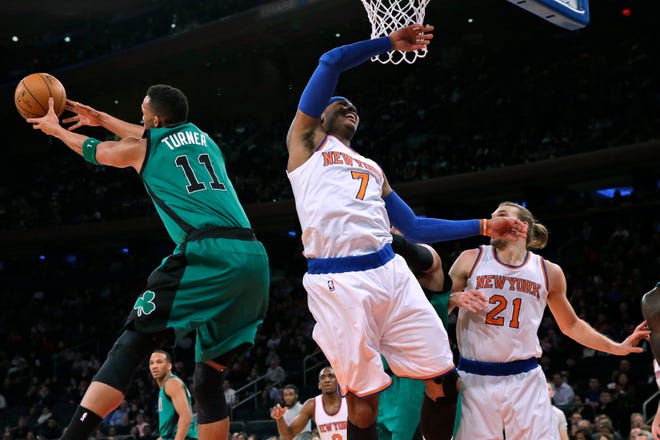 Boston's Evan Turner (11) reaches for the ball after blocking a shot by Carmelo Anthony (7) during the first half.