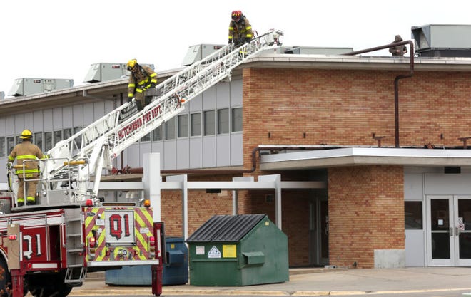 Hutchinson firefighters climb down off the roof of C hall, the far northeast building on the Hutchinson High School campus Wednesday afternoon, Feb. 4, 2015.. Ray Hemman, spokesman with USD 308, said that smoke during third hour caused the fire alarms to go off but at no time was there an actual fire at the school. Students were evacuated according to HHS plans and were able to return to inside areas of the campus not impacted by the alarm.