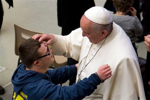 Pope Francis caresses a boy during his weekly general audience in the Paul VI hall at the Vatican, Wednesday, Jan. 21, 2015. Pope Francis is praising big families after saying Catholics don't have to breed "like rabbits." He says big families are a gift and don't cause poverty in the developing world, and that the real cause of poverty is an unjust economic system that idolizes money over people. (AP Photo/Andrew Medichini)