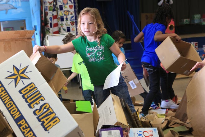 Ashley Stafford, 8, a second-grade student at Delalio Elementary School, selects a cardboard box for her project Wednesday morning. Ashley and other students will be creating arcade games out of cardboard. The students will join the other 90,000 participants in 49 countries to participate in the Global Cardboard Challenge.