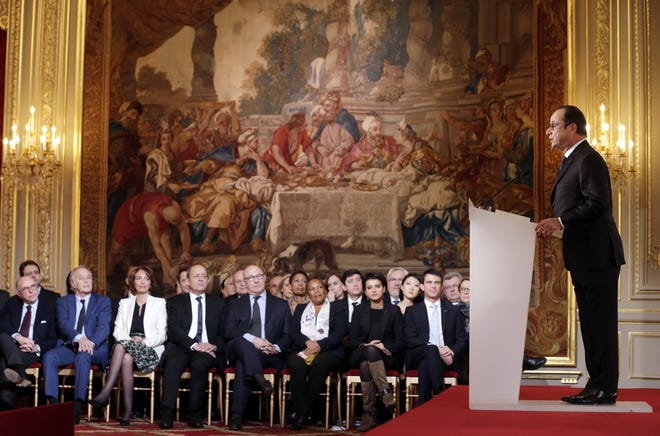 Members of the French government listen to French President Francois Hollande, right, during a press conference at the Elysee Palace in Paris, Thursday, Feb. 5, 2015.