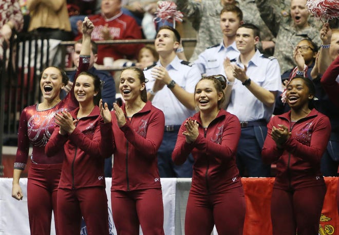 The Alabama gymnastics team cheer on Lora Leigh Frost during Frost's floor routine during a meet against the University of Florida held at Coleman Coliseum in Tuscaloosa, Ala. on Friday Jan. 23, 2015. staff photo | Erin Nelson