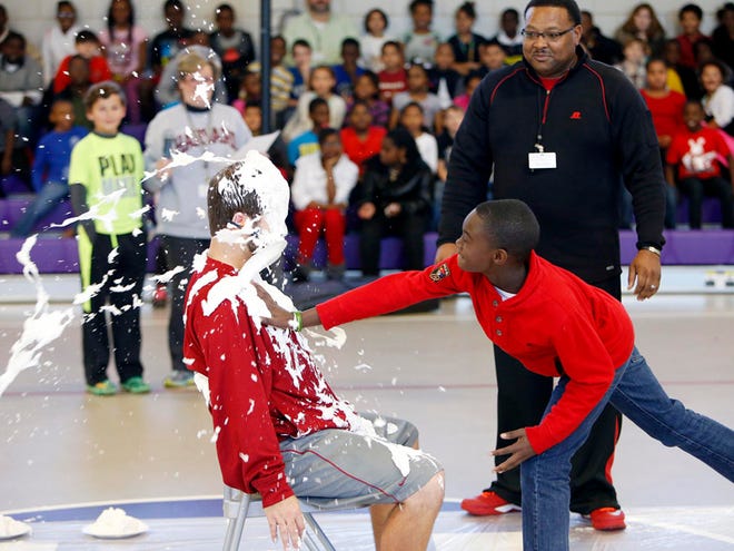 Mason Jones, 10, hits physical education teacher Mark Davis in the face with a whipped cream pie Thursday at Holt Elementary School in Tuscaloosa. Davis, who teaches physical education at Holt, was pied in the face by 30 students as their reward for raising $22 or more for the school's fundraiser for the American Heart Association. The school's goal was $500, and students raised $1,861. February is American Heart Month.