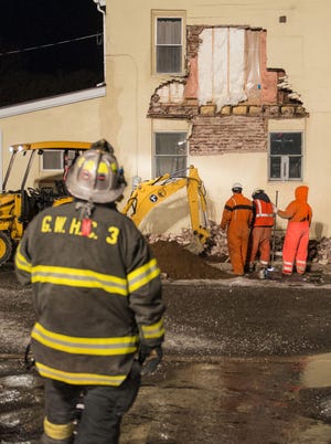 Fire companies stand by as PECO crews work to secure a gas line after the wall of a condemned building collapsed on Pine Street in Bristol on Feb. 2, 2015.