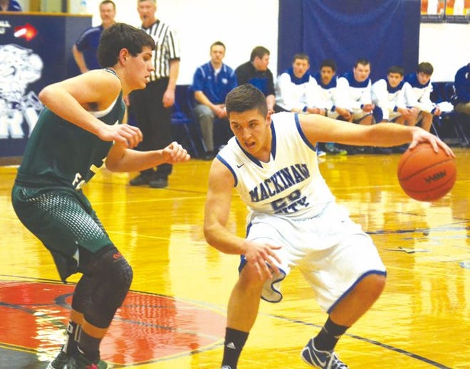Mackinaw City senior guard Jonah Robbins (right) looks to drive past Boyne Falls guard Andrew Stevens during the first quarter in Mackinaw City on Friday.