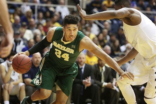 Baylor guard/forward Ishmail Wainright (24) drives past West Virginia forward Jonathan Holton, right, during the first half of an NCAA college basketball game, Saturday, Feb. 7, 2015, in Morgantown, W.Va.