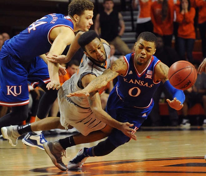 Kansas guard Brannen Greene, left, Oklahoma State guard Anthony Hickey, center, and Kansas guard Frank Mason III fall while chasing a loose ball during the final minutes of an NCAA basketball game in Stillwater, Okla., Saturday, Feb. 7, 2015. Hickey scored 15 points in the 67-62 win over Kansas.(AP Photo/Brody Schmidt)