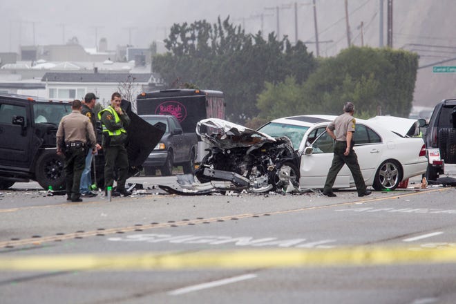 Los Angeles County Sheriff's deputies investigate the scene of a collision involving three vehicles in Malibu, Calif. on Saturday, Feb. 7, 2015. Officials said former Olympian Bruce Jenner was a passenger in one of the cars involved in the Pacific Coast Highway crash that killed one person. Jenner's publicist, Alan Nierob, says Jenner was unhurt. (AP Photo/Ringo H.W. Chiu)