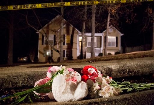 Flowers and teddy bears lay on the street outside the home of a shooting scene where authorities say five people are dead, including the gunman, in Douglasville, Ga. on Saturday, Feb. 7, 2015. Douglas County Sheriff's Lt. Glenn Daniel said the gunman shot six people before fatally shooting himself, and the two surviving victims are children, but children are also among the dead. (AP Photo/David Goldman)