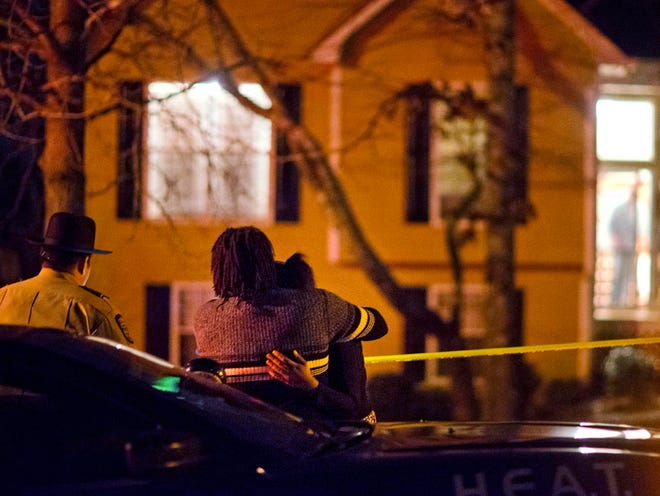 A couple embraces as they wait after requesting to speak with police officers upon arriving at the shooting scene where authorities say five people are dead, including the gunman, in Douglasville, Ga. on Saturday, Feb. 7, 2015. Douglas County Sheriff's Lt. Glenn Daniel said the gunman shot six people before fatally shooting himself, and the two surviving victims are children, but children are also among the dead.