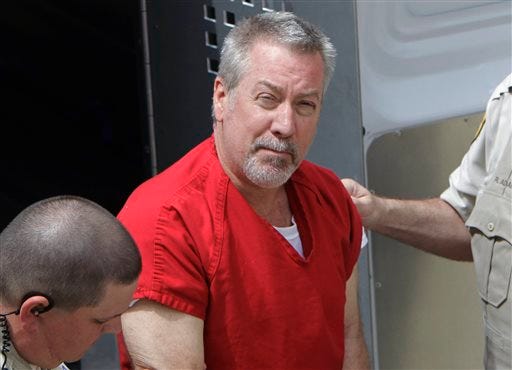 In this May 8, 2009 file photo, former Bolingbrook, Ill., police sergeant Drew Peterson arrives at the Will County Courthouse in Joliet, Ill., for his arraignment on charges of first-degree murder in the 2004 death of his third wife. State and local prosecutors said Monday, Feb. 9, 2015, that Peterson has been charged with solicitation of murder for hire and solicitation for murder after allegedly trying to hire someone to kill Will County State's Attorney James Glasgow, the prosecutor who led the 2012 trial that resulted in the former police officer being convicted of killing his third wife. (AP Photo/M. Spencer Green, File)