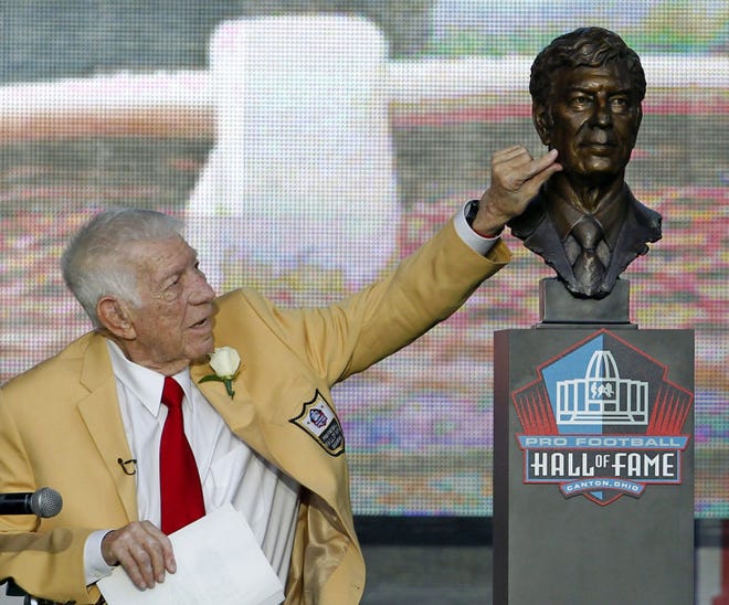 FILE- In this Aug. 6, 2011, file photo, Ed Sabol touches a bust of himself after it was unveiled during the induction ceremony at the Pro Football Hall of Fame in Canton, Ohio. Sabol, the NFL Films founder who revolutionized sports broadcasting and transformed pro football from an up-and-coming sport to must-watch theater died Monday, Feb. 9, 2015, the league said. He was 98. (AP Photo/Ron Schwane, File)