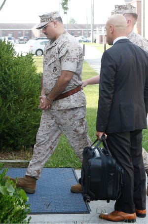 Cpl. Wassef Ali Hassoun is escorted to his Article 32 hearing aboard Camp Lejeune in August. One of Hassoun’s defense attorneys, Haytham Faraj, watches his client.