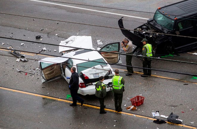 Los Angeles County Sheriff's deputies investigate the scene of a car crash where one person was killed and at least seven other's were injured Saturday. Olympic gold medalist Bruce Jenner was in one of the cars involved in the four-vehicle crash on the Pacific Coast Highway in Malibu, Calif.