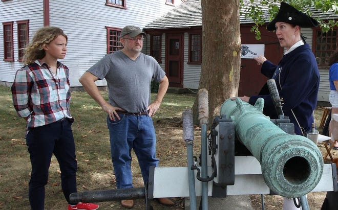 Jess McCabe and her father, Walter, listen to Ellie Hutchinson talk about the wheelless cannon at the Thayer House during the Braintree Historical Society's annual Heritage Day last fall.