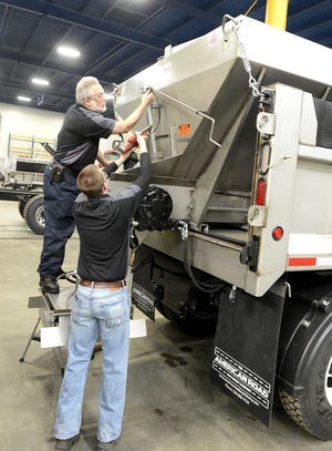 Frank Orlando and Parker Crissey of American Road Machinery in Perry Township assembled this snow plow truck for the Canton City Street Department. It is equipped with electronics that will allow employees to better track the application of salt to the roadways.