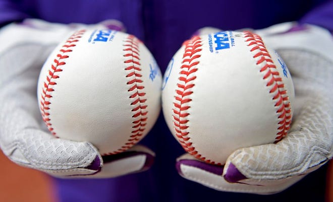 In this Jan. 23, 2015, photo LSU head coach Paul Mainieri shows the new flat-seam baseball, left, and a ball from last year, during LSU baseball's Media Day in Baton Rouge, La. After decades of trying to figure out the correct balance between offense and pitching, college baseball might have found a solution that sticks. The sport introduces the flat-seam baseball when the regular season opens on Friday, Feb. 13, which is supposed to help offensive production.