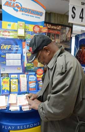 Marcellus Sutton fills out his PowerBall numbers Tuesday at CMart No. 4. The jackpot has grown to $485 million, the third-highest in the game’s history.