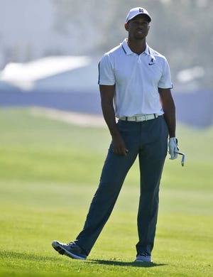 Tiger Woods appears frustrated after his short approach shot missed the green on the 10th hole of the north course at Torrey Pinesduring the first round of the Farmer Insurance Open golf tournament Thursday, Feb. 5, 2015, in San Diego. Woods later withdrew from the tournament with back problems. (AP Photo/Lenny Ignelzi)