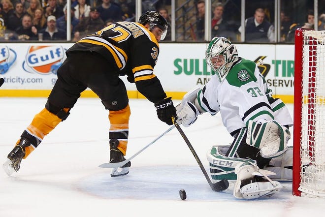 Boston Bruins' Patrice Bergeron goes for a rebound in front of Dallas Stars goalie Kari Lehtonen during the second period in Boston, Tuesday, Feb. 10, 2015.