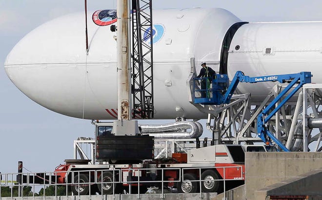 Maintenance is performed by workers on the Falcon 9 SpaceX rocket at launch complex 40 at the Cape Canaveral Air Force Station in Cape Canaveral, Fla., Monday. The Sunday launch attempt was scrubbed and SpaceX will try again on Wednesday evening. (AP Photo/John Raoux)