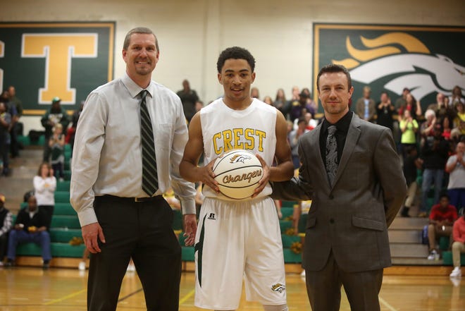 Crest High's Jerick Haynes, centered, was honored after breaking the school's career scoring mark, passing legendary David Thompson, Tuesday night at Ed Peeler Gym. With Haynes are athletic director Jeff Melton, left, and head coach Justin Zaleski. (Ben Earp / The Star)