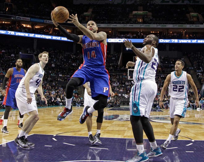 Detroit Pistons' D.J. Augustin (14) drives past Charlotte Hornets' Al Jefferson (25) and Cody Zeller (40) during the first half of an NBA basketball game in Charlotte, N.C., Tuesday, Feb. 10, 2015. (AP Photo/Chuck Burton)
