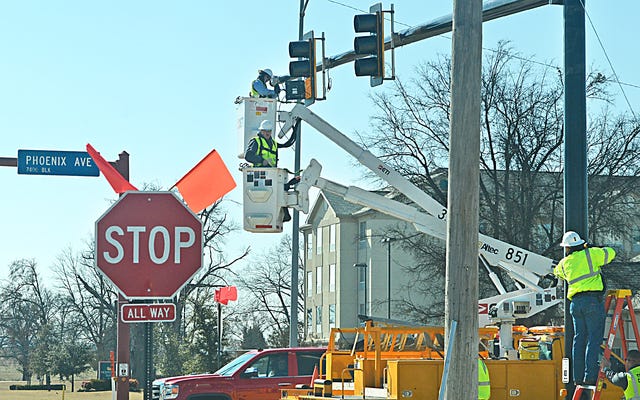 BRIAN D. SANDERFORD • TIMES RECORD / Workers with the city of Fort Smith road department install a new traffic signal at Phoenix Avenue and 74th Street on Tuesday. The intersection had been a four-way stop for the past five days after an accident damaged the signal pole.